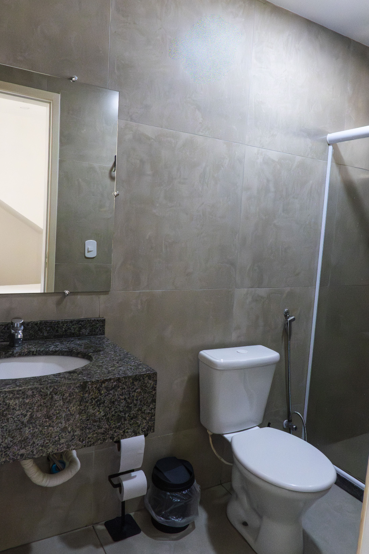 Quarto Tainha — banheiro com bancada em granito, vaso e box