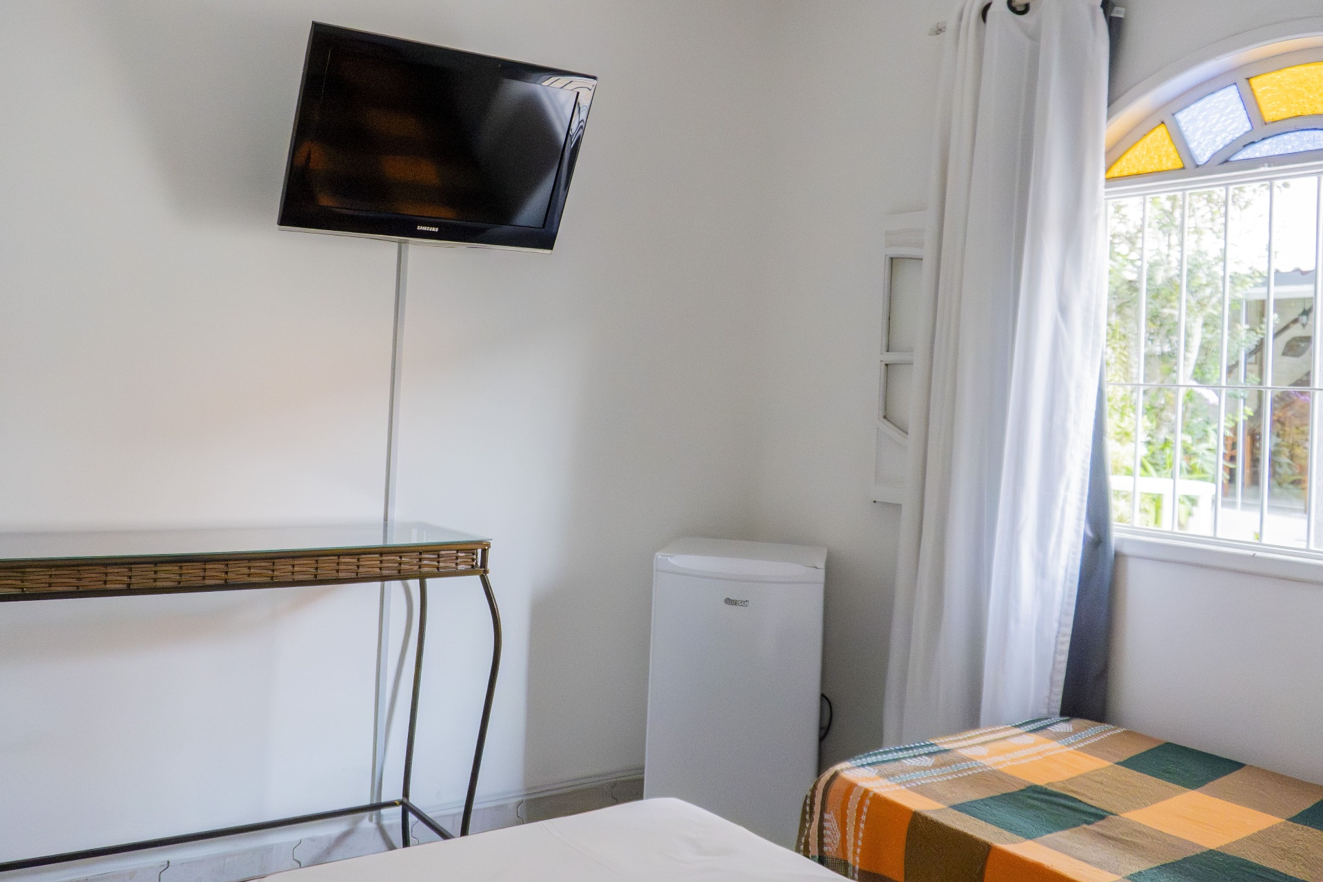 Quarto Manjubinha — TV e frigobar com vista para o jardim