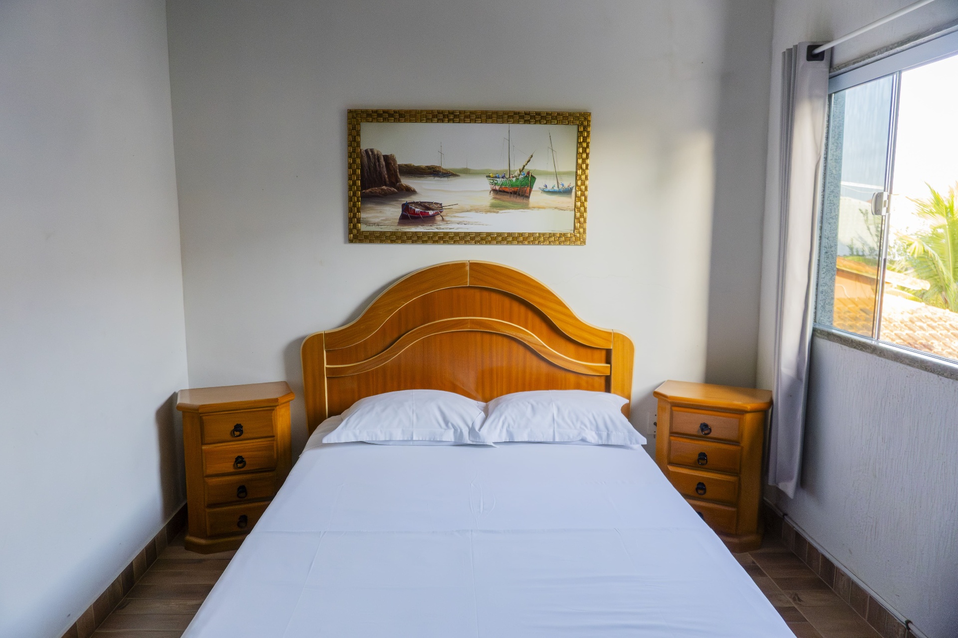 Quarto Dourado — cama de casal com quadro náutico