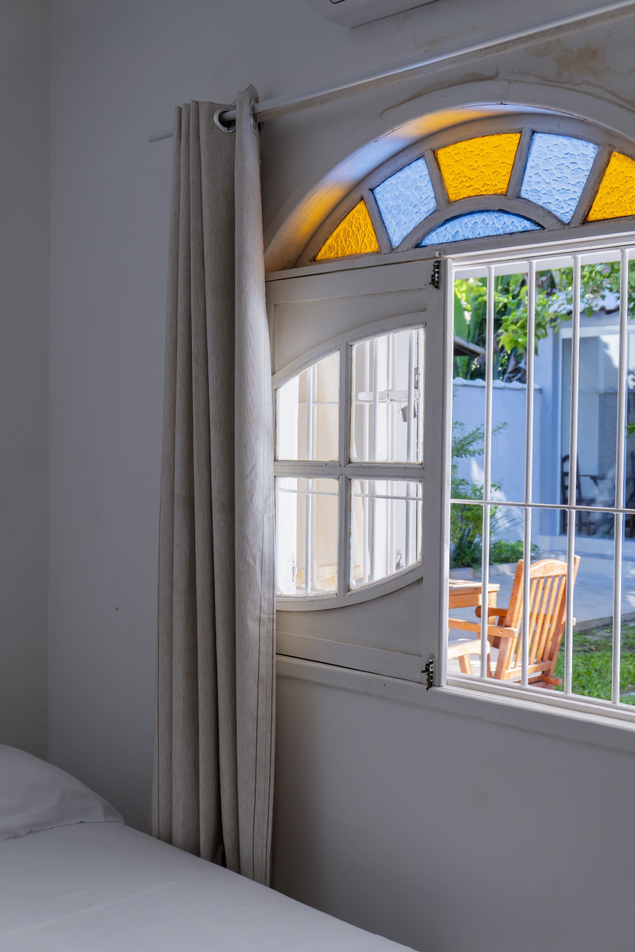 Quarto Cavalinha — vista da janela para o jardim com cadeiras