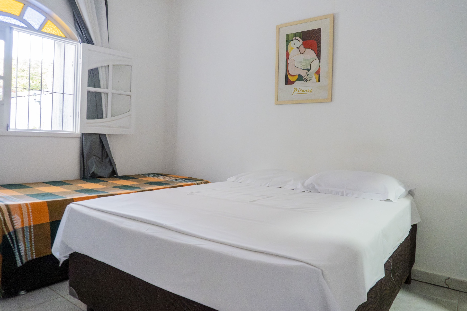 Quarto Manjubinha — cama de casal com quadro Picasso