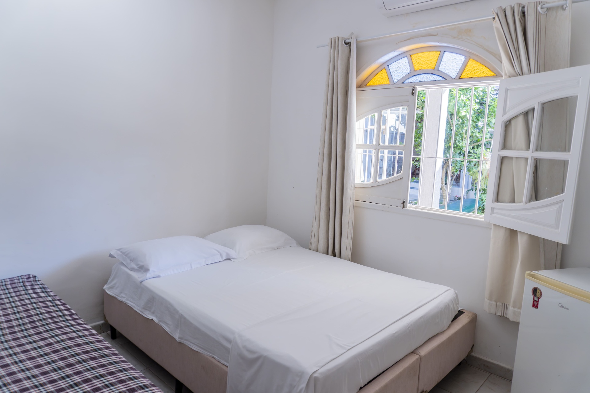 Quarto Cavalinha — cama de casal com cama auxiliar e janela em arco