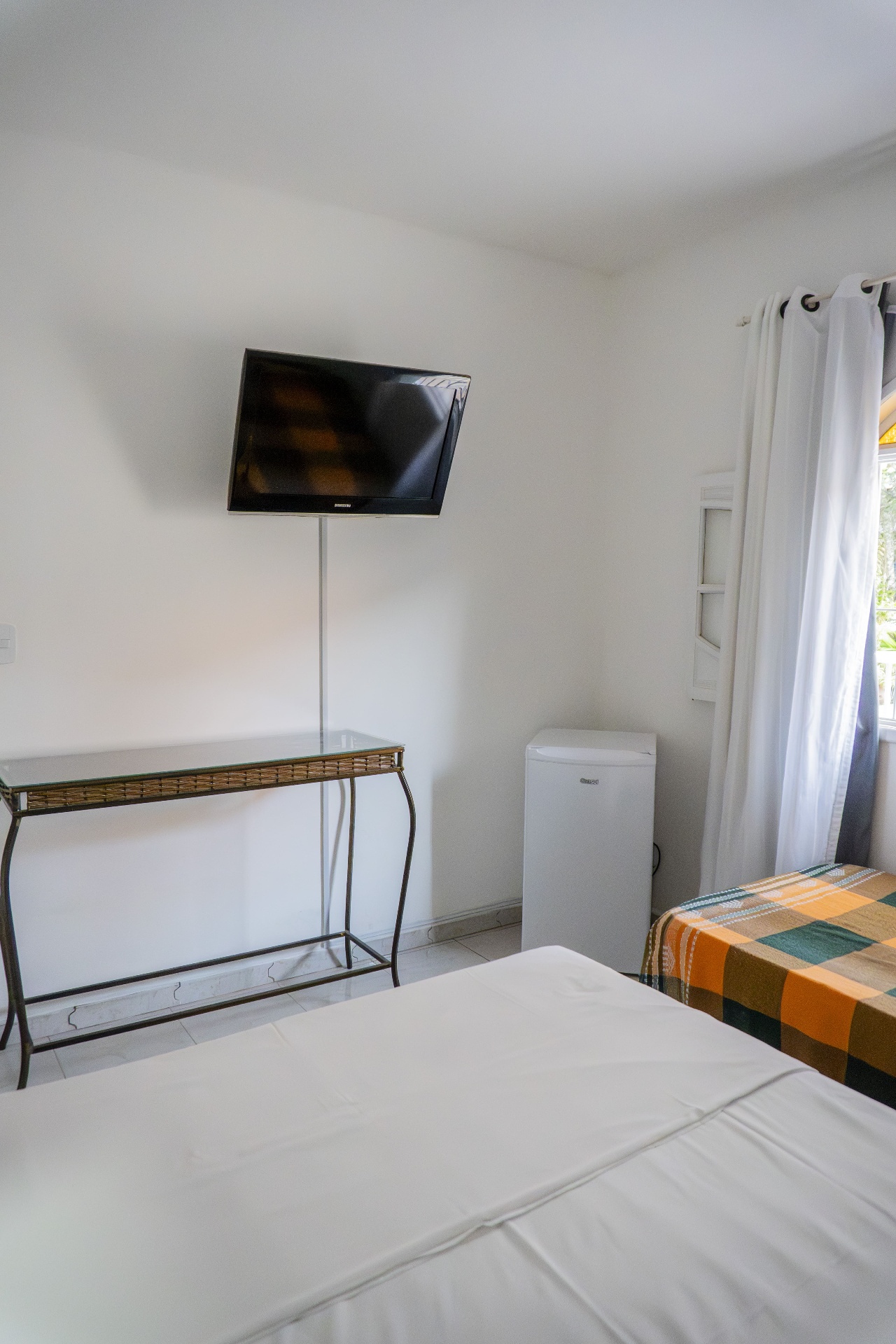 Quarto Manjubinha — TV, console e frigobar
