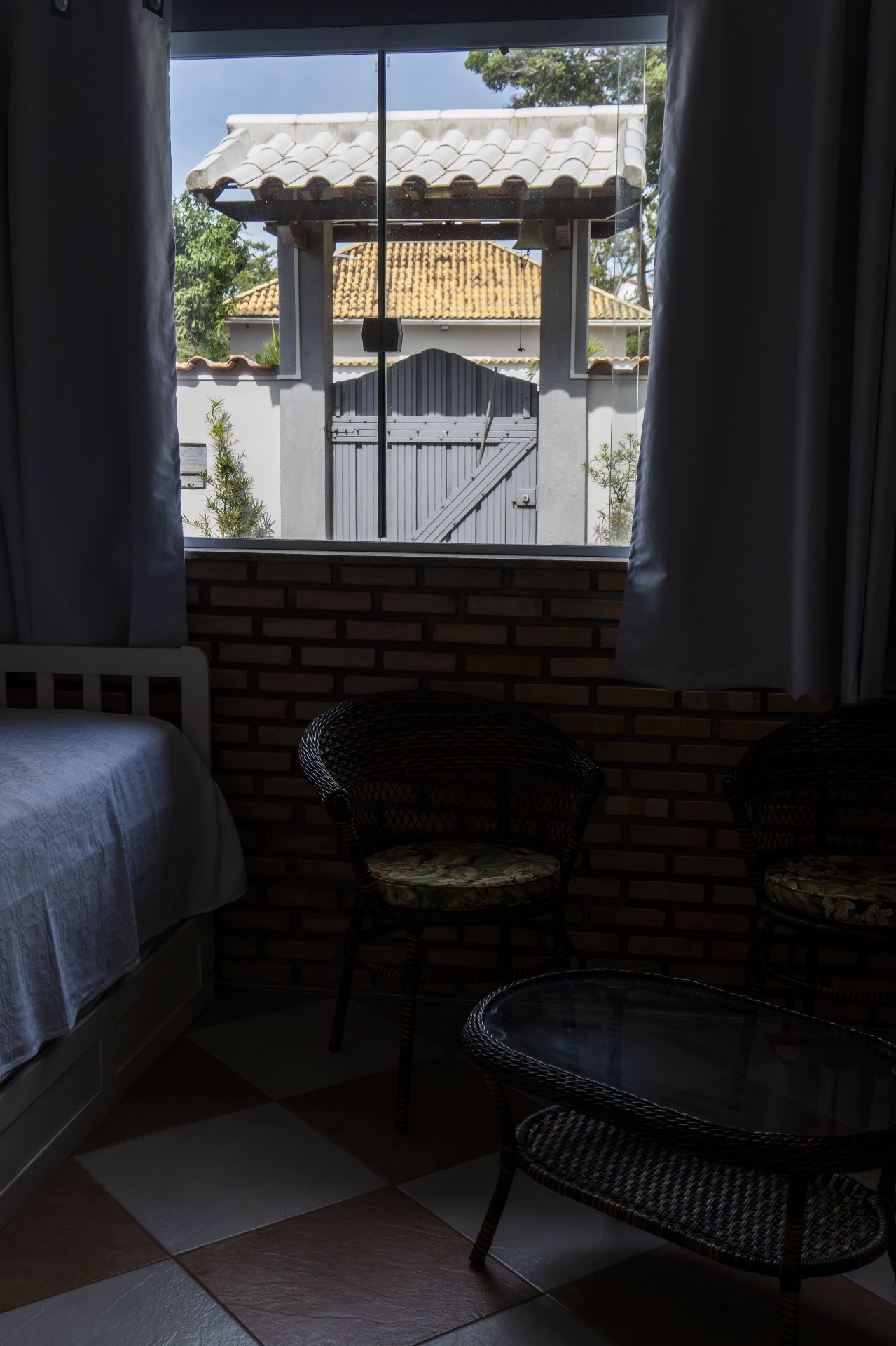 Quarto Tainha — vista da varanda com poltronas e mesa