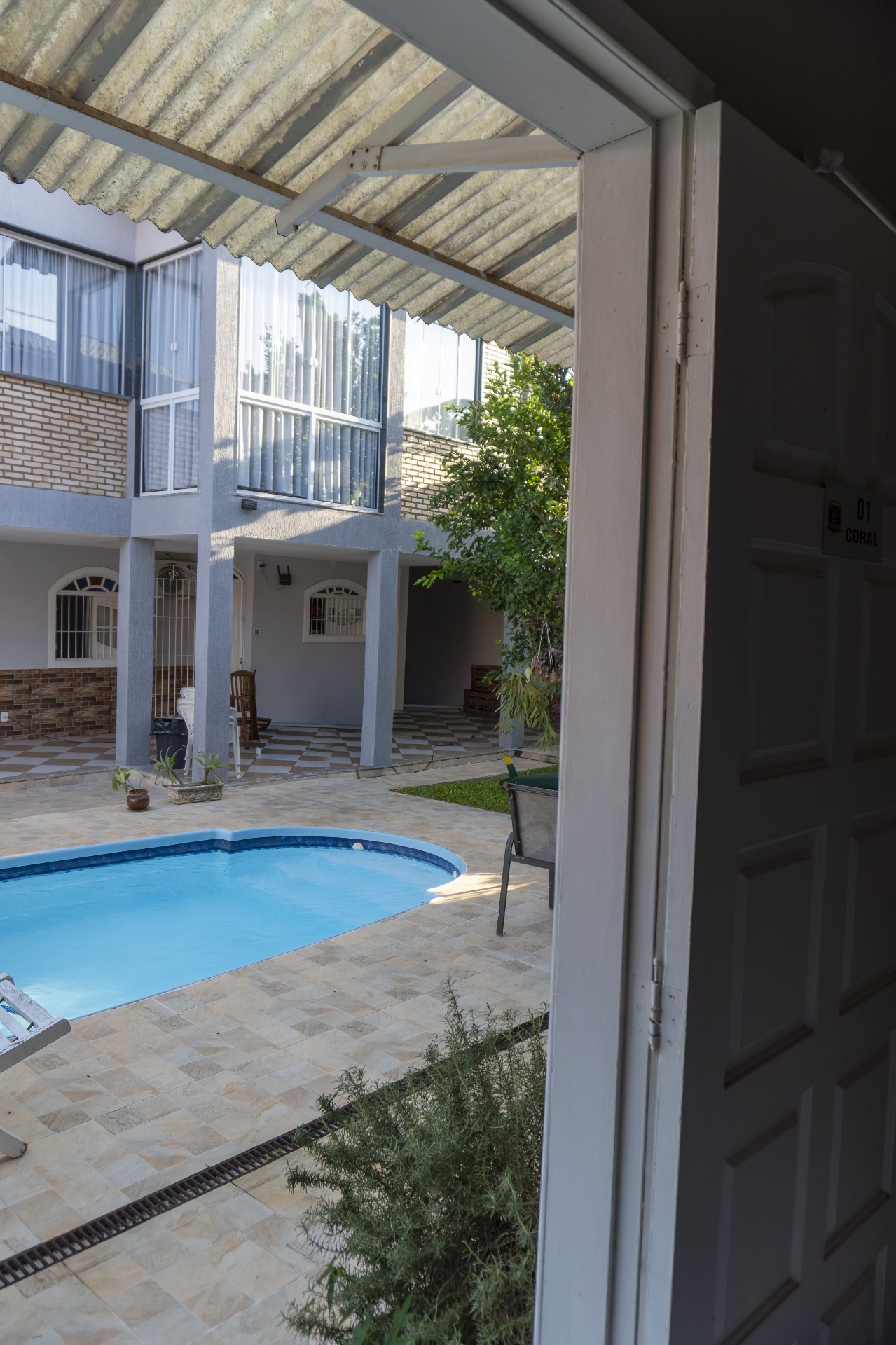 Quarto Coral — vista da porta para a piscina