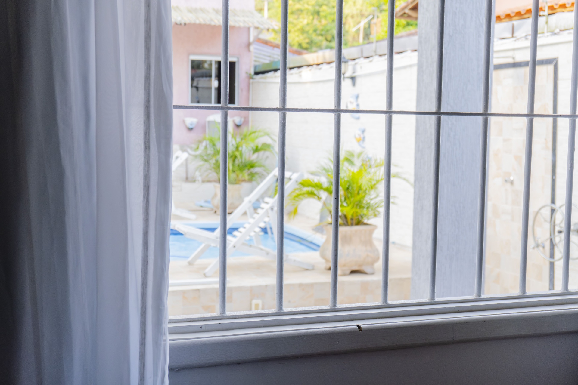 Quarto Manjubinha — vista da piscina pela janela