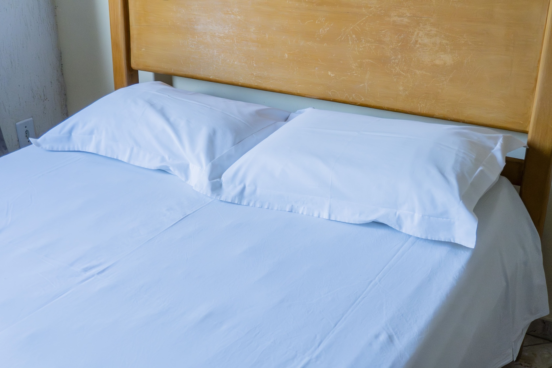Quarto Marlim Azul — detalhe da cabeceira e roupa de cama