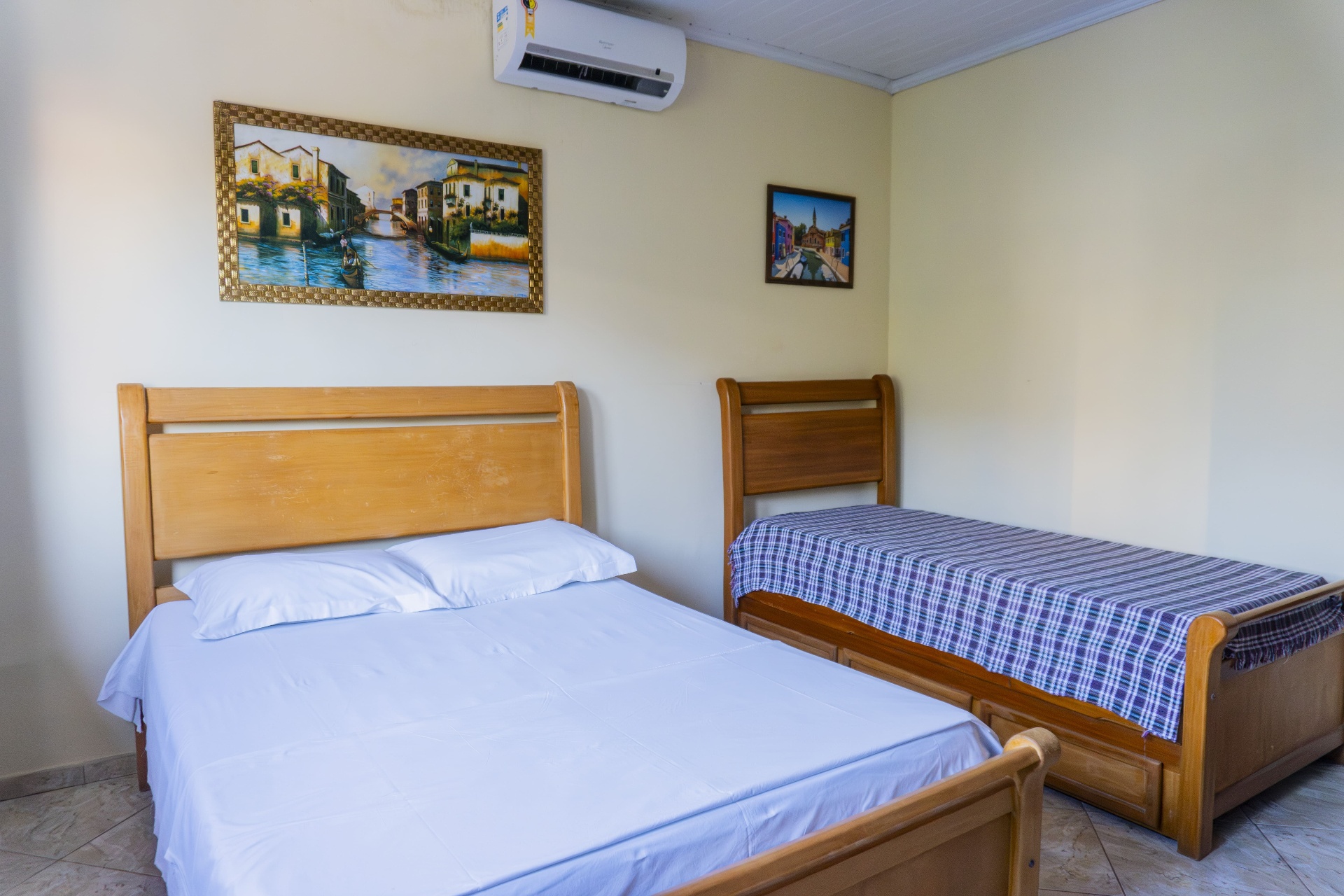 Quarto Marlim Azul — vista das duas camas com quadros decorativos