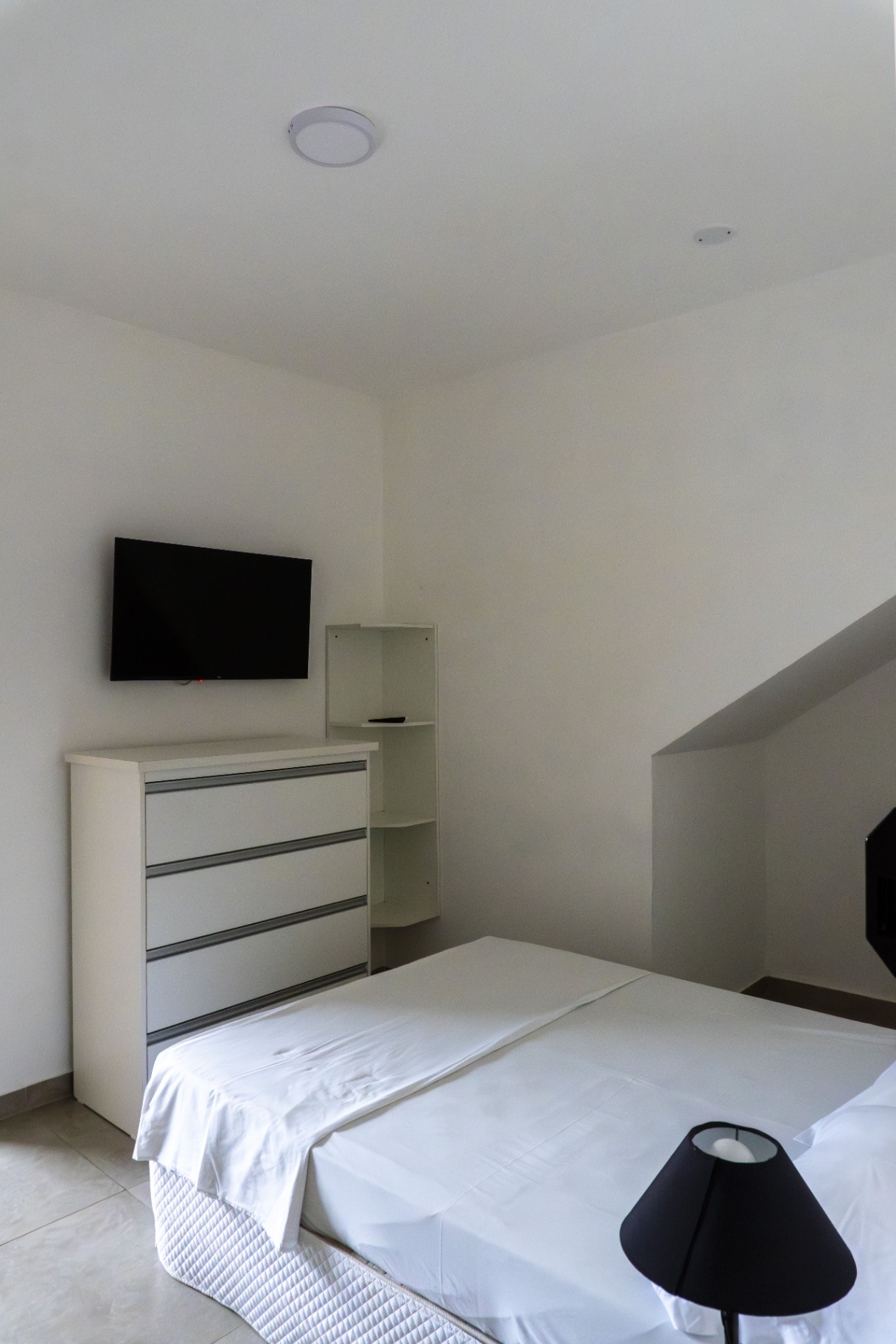 Quarto Tainha — TV, cômoda e nicho de apoio