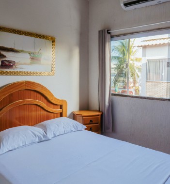 Quarto com cama de casal e vista para o jardim