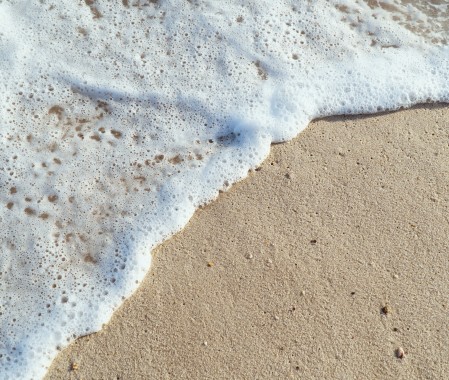 Espuma do mar na areia de Itaúna